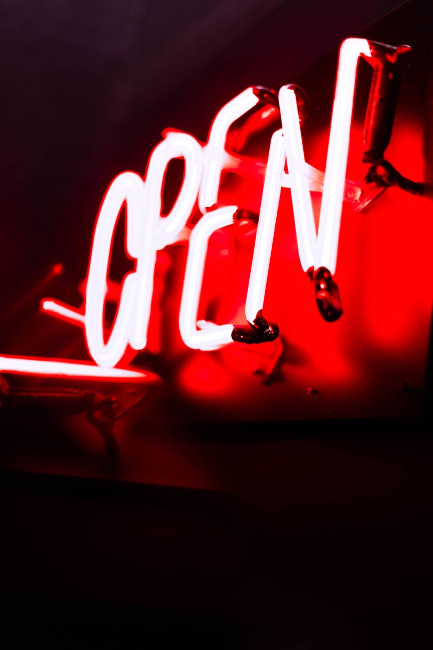 Close-up of a red neon open sign glowing in the dark